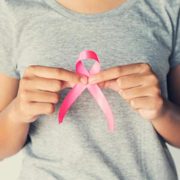 womaen hand holding pink ribbon breast cancer awareness. concept healthcare and medicine